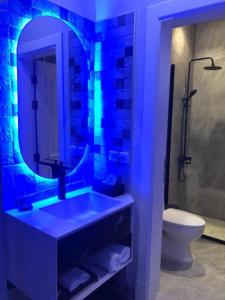 a bathroom with a sink with a mirror and a toilet at Dana Riyadh Hotel & Residence in Riyadh