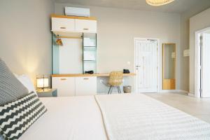 a bedroom with a white bed and a kitchen at Villa dei Venti in Qala
