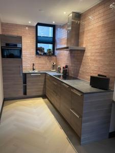 a kitchen with wooden cabinets and a counter top at Villa B&B Bovenkarspel in Bovenkarspel