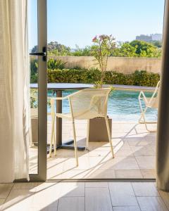 a patio with two chairs and a table and a pool at Villa dei Venti in Qala