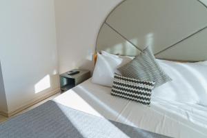 a bedroom with a white bed with a pillow on it at Villa dei Venti in Qala