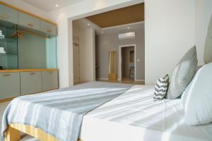 a bedroom with a large white bed and a kitchen at Villa dei Venti in Qala