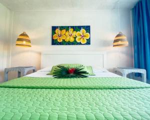 Un dormitorio con una cama verde con un arreglo floral encima. en Greenwood Beach Resort, en Bailey Town