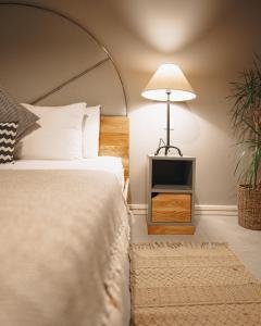 a bedroom with a bed with a lamp and a plant at Villa dei Venti in Qala