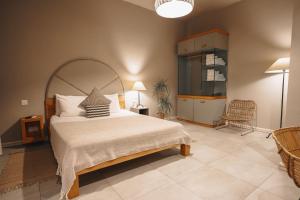 a bedroom with a large bed and a chair at Villa dei Venti in Qala