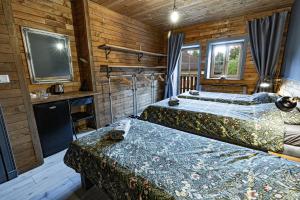 two beds in a room with wooden walls at Liptov Lodge in Liptovský Mikuláš