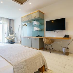 a bedroom with a bed and a desk with a television at Villa dei Venti in Qala