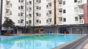 an empty swimming pool in front of a building at Comfort and Cozy Living 2BR at Cibubur Village Apartment By Travelio in Depok