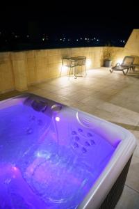 a purple hot tub on a patio at night at Villa dei Venti in Qala