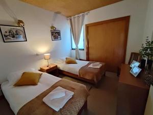 una camera d'albergo con due letti e una finestra di Special place in São Pedro do Sul a São Pedro do Sul