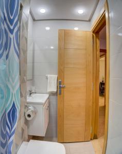 une salle de bain avec toilettes et porte en bois dans l'établissement Welcome to Timitar, Your Home 6!, à Agadir