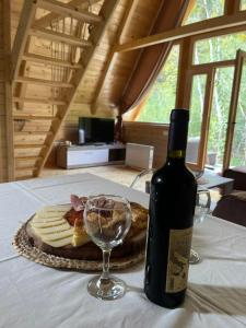 a bottle of wine and a plate of cheese and a glass at Holiday Home Veruša in Podgorica +16 photos