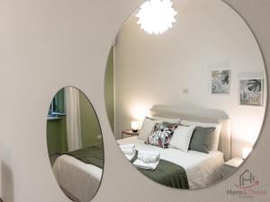 a bedroom with a mirror in front of a bed at Venice Suite - Cruises 500m - AC - Smart TV in Genova