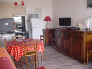una cocina con una mesa y una cocina con un televisor en MAGNIFIQUE VUE MER et PHARE DE CORDOUAN, en Saint-Palais-sur-Mer
