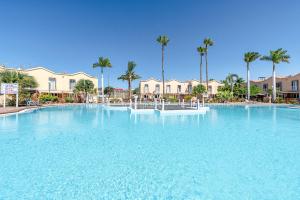 a large pool of blue water in a resort at Zen House in Maspalomas