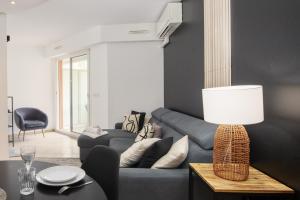 a living room with a blue couch and a table at "Le beach", plein centre, climatisé in Menton