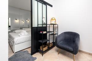 a bedroom with a black chair and a bed at "Le beach", plein centre, climatisé in Menton +16 photos