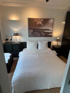 a large white bed in a room with two lamps at Mar y sal in Knokke-Heist