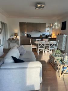 a living room with a couch and a table and a kitchen at Mar y sal in Knokke-Heist