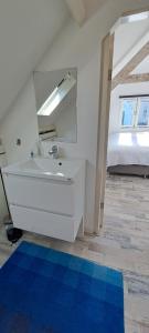 a white bathroom with a sink and a mirror at zilvermeeuw in Bergen aan Zee