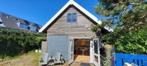 a small shed with a door in a yard at zilvermeeuw in Bergen aan Zee