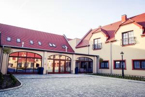 un bâtiment avec des toits rouges et une cour dans l'établissement Hotel Pałac Krotoszyce Basen&Spa, à Krotoszyce