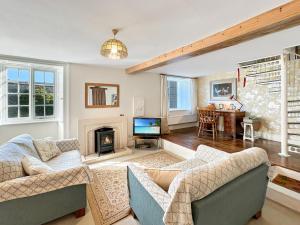 un salon avec deux canapés et une cheminée dans l'établissement Orchard Cottage, à Charles