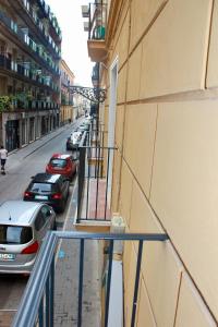 un balcón de un edificio con coches aparcados en la calle en C'est La Vie, en Caserta