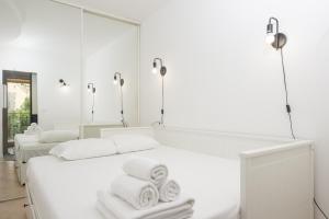 a white bedroom with two beds and mirrors at "Le beach", plein centre, climatisé in Menton