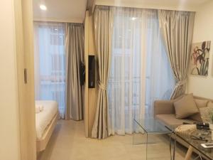 ein Wohnzimmer mit einer Couch und einem Glastisch in der Unterkunft Olympus city garden by jack in Pattaya South