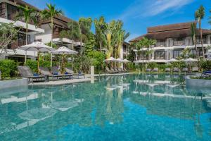 a swimming pool at a resort with chairs and umbrellas at Amari Koh Samui in Chaweng