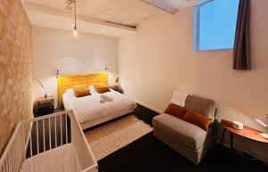 リールにあるLe Quai - Appartement spacieux et calme, 3 chambres, Idéal familles et professionnels, Vieux Lilleのベッドとソファと椅子のある寝室