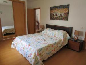 Un dormitorio con una cama con un edredón floral. en Spacious Apartment in Old Ferragudo Village, en Ferragudo
