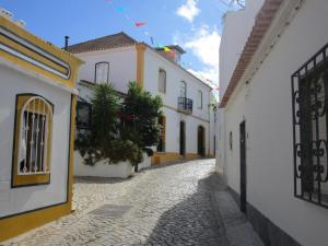 un callejón en una ciudad con edificios blancos y amarillos en Spacious Apartment in Old Ferragudo Village, en Ferragudo