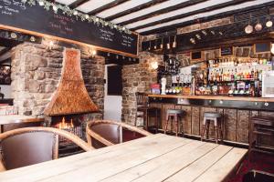 a pub with a wooden table and a bar at The Street Head Inn in West Burton