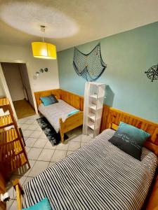 a bedroom with two beds in a room at Au pays d'Hector Berlioz in La Côte-Saint-André
