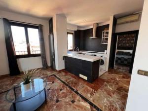 duży salon ze stołem i kuchnią w obiekcie Apartamentos El Tiempo Madrid w Madrycie