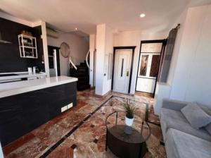 salon z kanapą i stołem w obiekcie Apartamentos El Tiempo Madrid w Madrycie