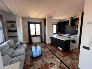 salon z kanapą i kuchnią w obiekcie Apartamentos El Tiempo Madrid w Madrycie