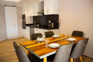 a dining room table with chairs and a kitchen at Vacation home with private pool, Fethiye, Oludeniz in Cedit