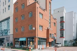a red brick building on the corner of a street at Denmaru in Sokcho