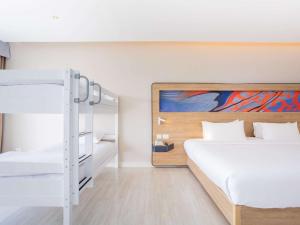 a bedroom with two bunk beds and a mirror at Novotel Phuket City Phokeethra in Phuket Town