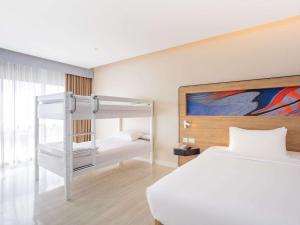 a bedroom with a bed and a bunk bed at Novotel Phuket City Phokeethra in Phuket Town