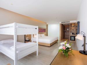 a bedroom with two bunk beds and a room at Novotel Phuket City Phokeethra in Phuket Town