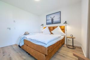 ein Schlafzimmer mit einem großen Bett mit einem hölzernen Kopfteil in der Unterkunft Ferienwohnung Wiking-Koje 2 Schleswig in Schleswig