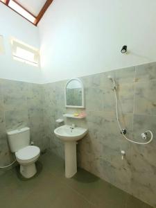 Un baño con inodoro, lavabo y ducha. en Serene Lush Holiday Home, en Tangalle