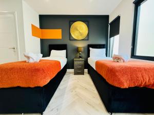 - une chambre avec 2 lits avec des draps orange dans l'établissement Central One Bedroom Flat Next to Brighton Beach I Sleep 5 Guests, à Brighton et Hove