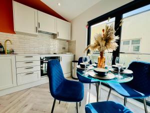 une cuisine avec une table et des chaises bleues dans l'établissement Central One Bedroom Flat Next to Brighton Beach I Sleep 5 Guests, à Brighton et Hove