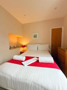 a bedroom with a large white bed with red blanket at The Western in St Ives