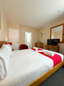 a large white bed in a room with a mirror at The Western in St Ives